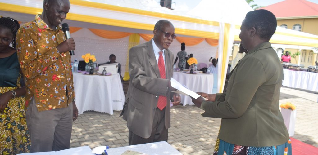 VC Prof Dr Jasper Ogwal Okeng handsover certificate to a graduand